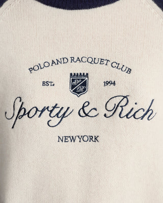Close-up of a label with 'Polo and Racquet Club' and 'Sporty & Rich New York' text on a white background.