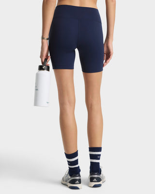 Person wearing navy blue athletic shorts and socks on a white background