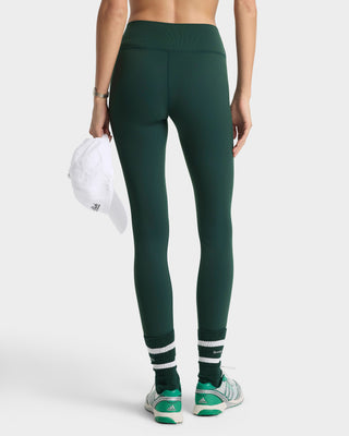 Person wearing green leggings with white stripes on a white background