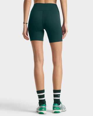 Person wearing green athletic shorts and socks on a white background