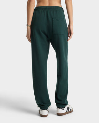 Green sweatpants worn by a person on a white background
