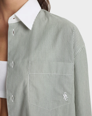 Close-up of a person wearing a green and white striped shirt with a brand logo on a white background