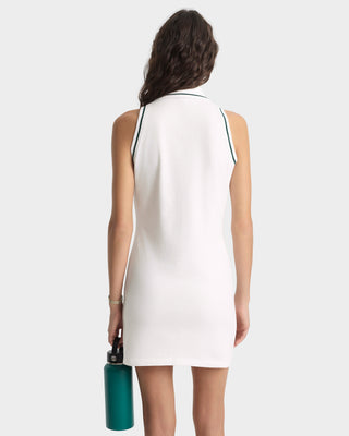 Woman wearing a white sleeveless dress holding a green water bottle on a white background