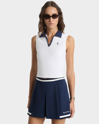 Woman wearing a white sleeveless top and navy skirt with a logo on a white background