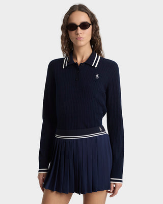 Woman wearing a navy blue dress with white accents on a white background