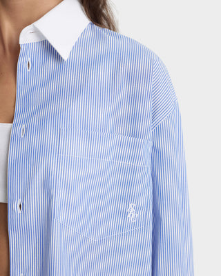 Blue and white striped shirt with a brand logo on a white background