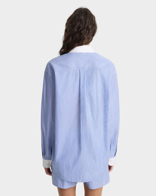 Person wearing a light blue striped shirt on a white background