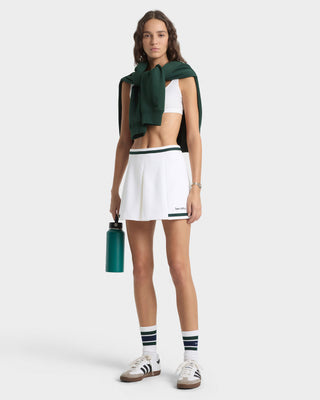 Woman in athletic wear holding a water bottle on a white background