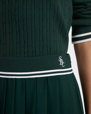 Green cable knit sweater with a logo on a white background