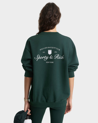 Person wearing a green sweatshirt with 'Sporty & Rich' branding on the back.