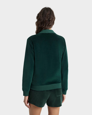 Person wearing a green sweater and shorts on a white background