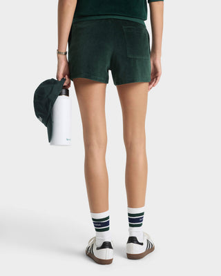 Person wearing green shorts and white socks with dark blue stripes on a white background