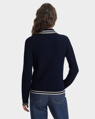 Person wearing a navy sweater with white stripes on a white background