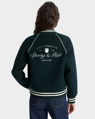 Person wearing a dark green jacket with 'Sporty & Rich New York' branding on the back.
