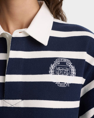 Navy and white striped polo shirt with a logo on a close-up of the chest area.