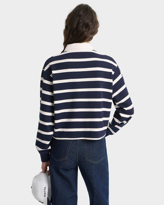 Person wearing a navy and white striped sweater with a plain background