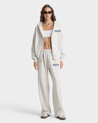 Woman wearing a white 'Yale' tracksuit on a white background