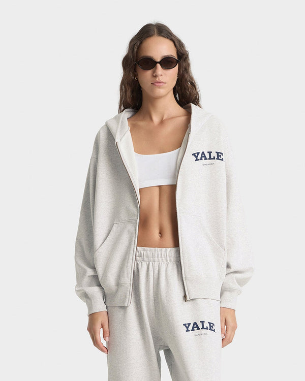 Woman wearing a white 'Yale' tracksuit on a white background