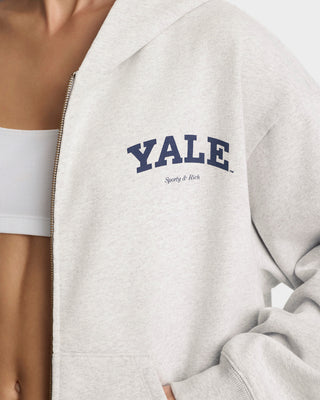 Gray jacket with 'Yale' logo on a person wearing a white top.