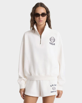 Woman wearing a white Yale sweatshirt and shorts on a white background