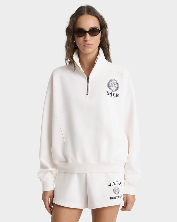 Woman wearing a white Yale sweatshirt and shorts on a white background