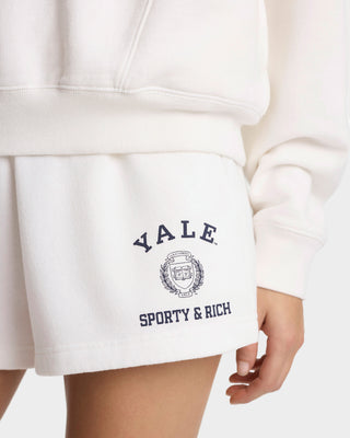White shorts with 'Yale Sporty & Rich' text and logo on a white background