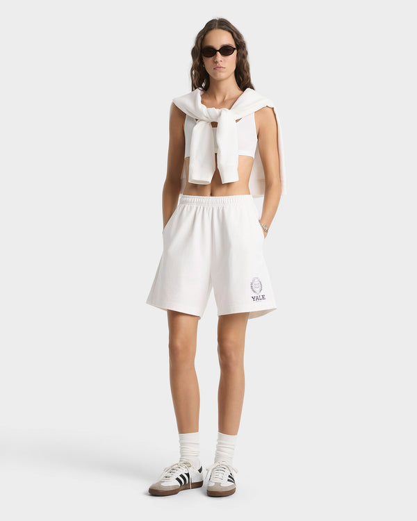 Woman wearing a white outfit with a logo on a white background