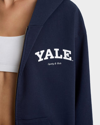 Navy blue jacket with 'YALE' and 'Sporty & Rich' text on a white background
