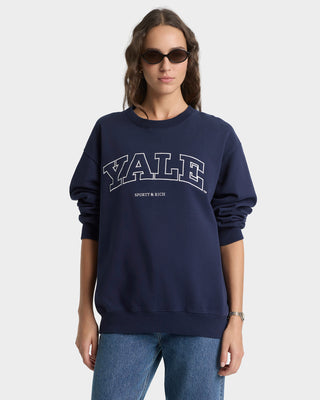 Person wearing a navy blue 'Yale' sweatshirt on a white background