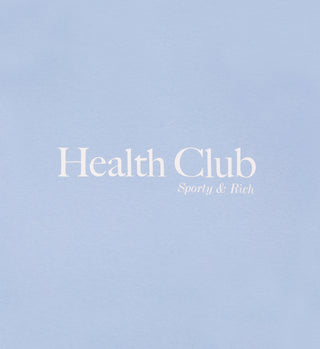 The Health Club T-Shirt - Sky Blue/White features white Sporty & Rich text on light blue, made in the USA from premium USA-grown cotton for unisex comfort and classic style.
