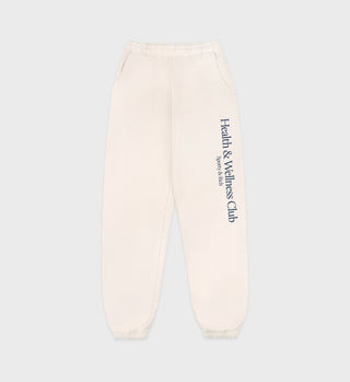 The H&W Crest Sweatpant - Cream/Navy features Health & Wellness Club and Sports Skills text on the right leg, crafted from USA grown cotton for quality and comfort.