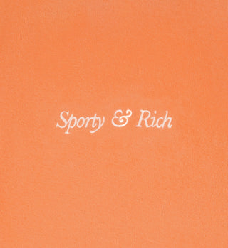 The Italic Logo Velour Polo - Peach/White features white cursive “Sporty & Rich” embroidery at the center. Made from 100% cotton and crafted in Portugal.