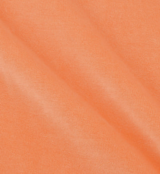 Close-up of soft peach fabric with diagonal folds and a slightly textured surface, crafted from 100% cotton as seen in the Italic Logo Velour Polo - Peach/White, made in Portugal.