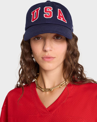 Woman facing forward wearing a navy USA Hat - Navy/Sports Red/White with adjustable closure, a red shirt, and a gold chain necklace.