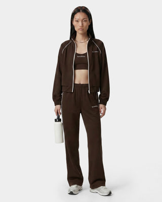Person wearing a brown tracksuit with a white background