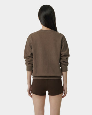 Person wearing a brown sweatshirt and shorts on a white background