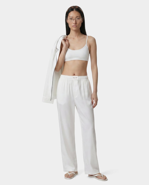 Woman wearing a white outfit on a plain background