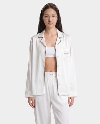 Woman wearing a white satin outfit with 'Bodysuit' label on a white background