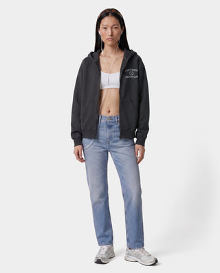 Person wearing a black hoodie, light blue jeans, and white sneakers on a white background