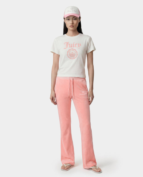 Woman wearing a white Juicy couture t-shirt with pink text and pink pants on a white background