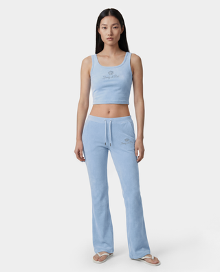 Woman wearing a light blue juicy tank top and pants juicy couture on a white background