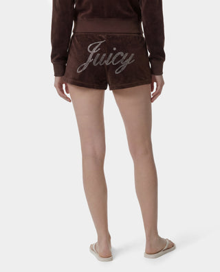 Brown 'Juicy' shorts worn by a person on a white background