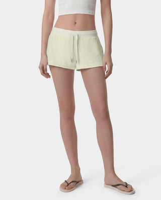 Person wearing light green shorts on a white background
