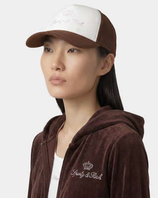 woman wearing a brown hoodie and cap with visible branding on a white background