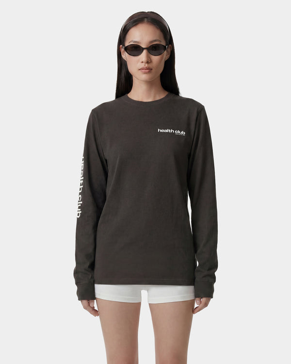 Person wearing a black long-sleeve shirt with 'health club' text on a white background