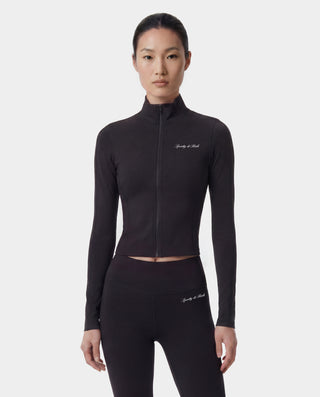 Woman wearing a black athletic outfit with branding on a white background