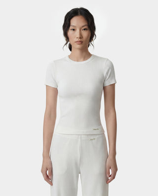 Woman wearing a white ribbed t-shirt and pants on a white background