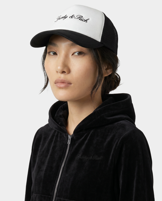 Person wearing a black and white cap with 'Yohji & Rich' branding on a white background