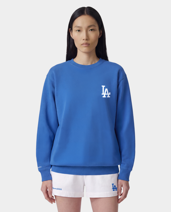 LA Serif Crewneck - Team Blue/White, an oversized crewneck crafted from 100% cotton in team blue, features a white LA logo on the left chest and is displayed laid flat on a white background.
