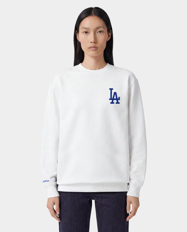 LA Serif Crewneck - White/Team Blue features an oversized fit and is made from 100% cotton, showcasing a blue LA logo on the upper left chest. Displayed on a plain light gray background.
